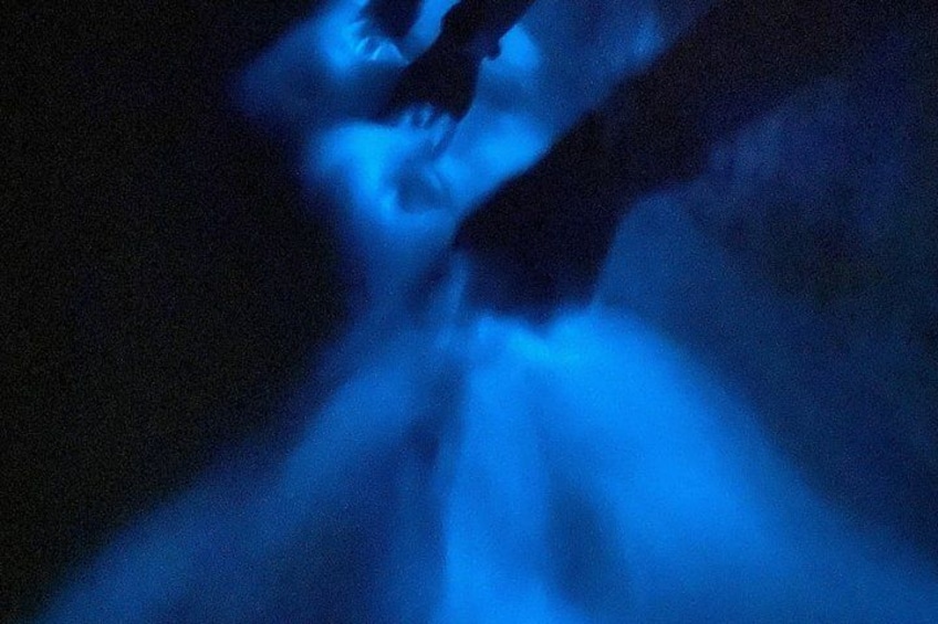 Une personne se trouve dans un environnement éclairé d’une lumière bleue, peut-être dans une grotte ou sous l’eau. 3