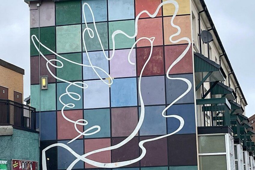 Fachada colorida de un edificio con un gran dibujo abstracto en blanco. 4