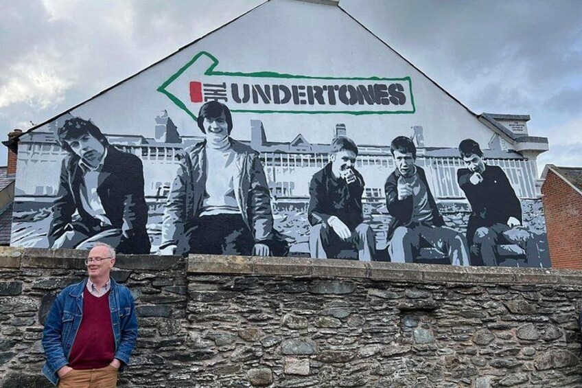 A mural with the word 'UNDERTONES' and a green arrow pointing left. 1