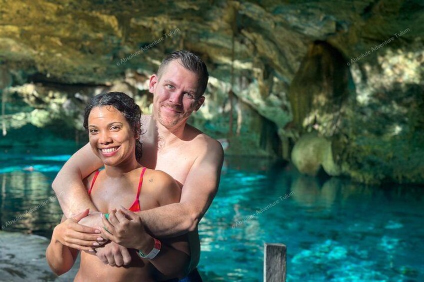 Una pareja abrazándose en una piscina subterránea con paredes de roca. 2