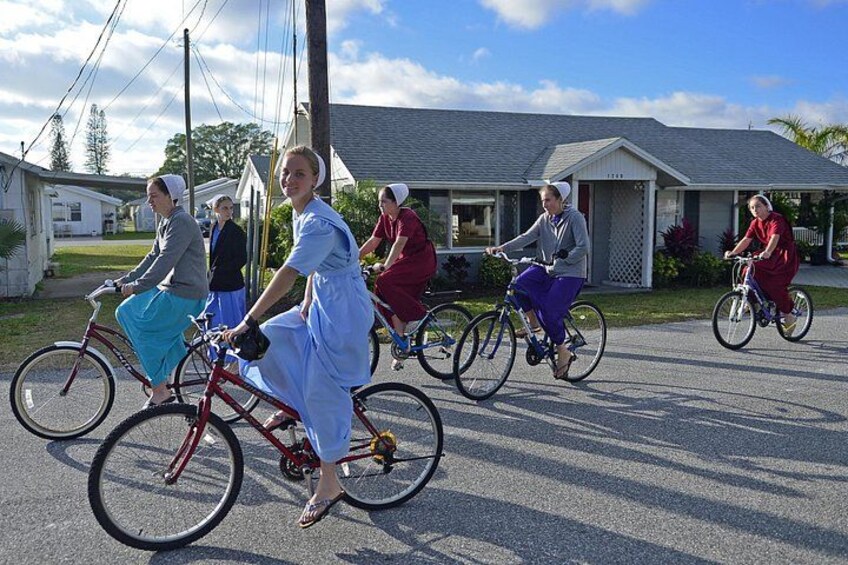 En grupp människor som cyklar på en bostadsgata. 1