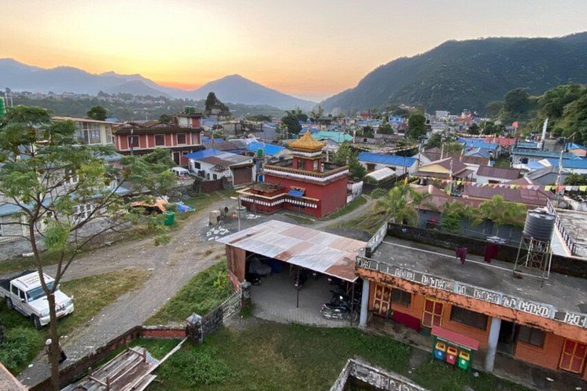 A village with buildings, a temple, and mountains in the background. 5