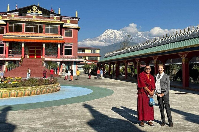 A building with a red facade, a courtyard with a fountain, and a mountain in the background. 3