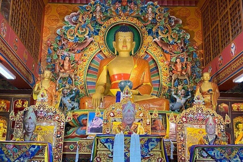 A large Buddha statue surrounded by intricate decorations and smaller statues. 4