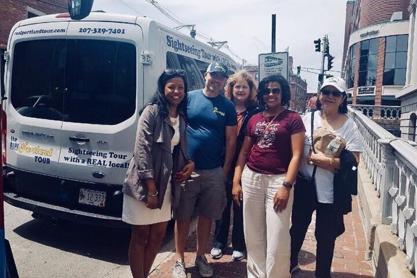 Un autobús turístico para visitas guiadas con personas de pie a su lado. 3