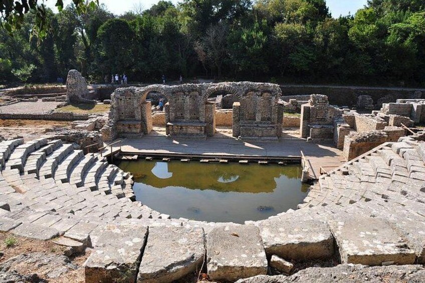 Ruinas antiguas con una fuente central y asientos de piedra. 4