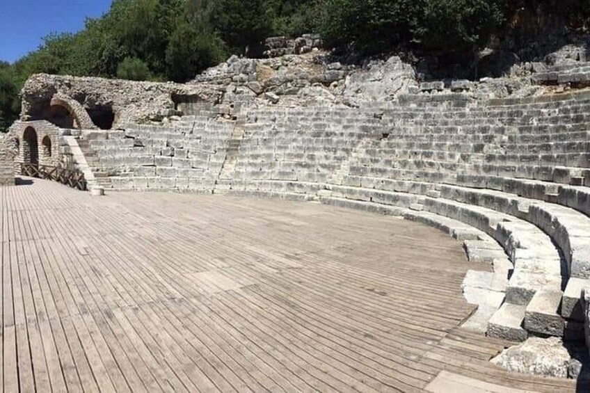 Un antiguo anfiteatro con escalones de piedra y un escenario de madera. 2
