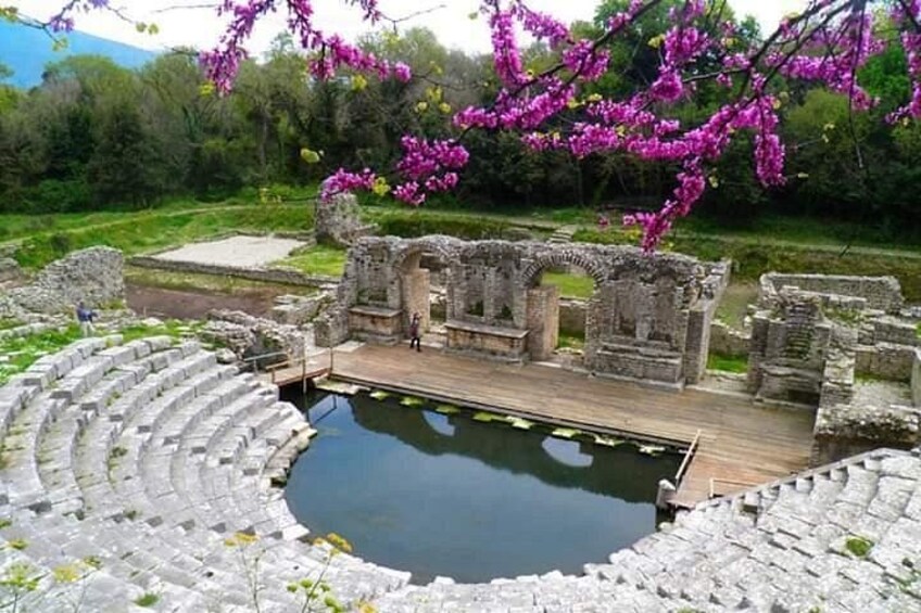 Un anfiteatro antiguo con un escenario de madera y una piscina. 1