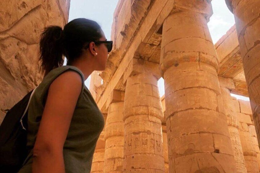A person standing between ancient stone columns with hieroglyphics. 2