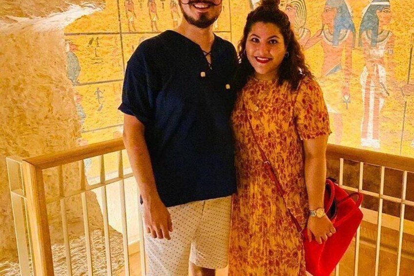 A man and a woman standing in front of a wall with ancient Egyptian hieroglyphs. 5