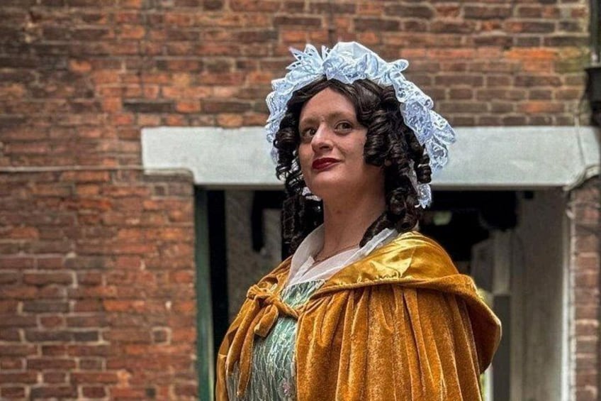 Una persona vestida con traje de época frente a un edificio de ladrillo. 4
