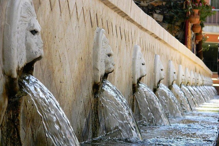 A series of stone sculptures with water flowing from their mouths. 4