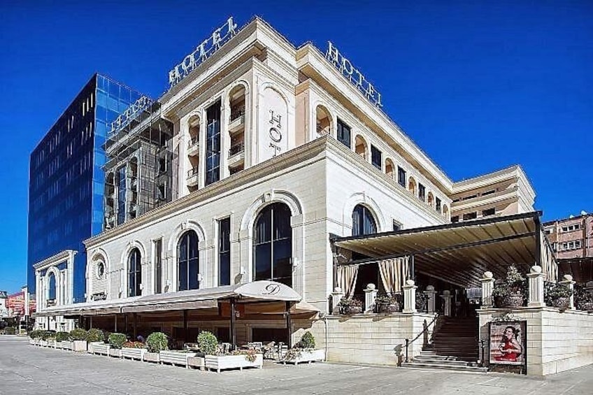 A historic hotel with a classic facade, a covered entrance, and a staircase leading to the entrance. 3