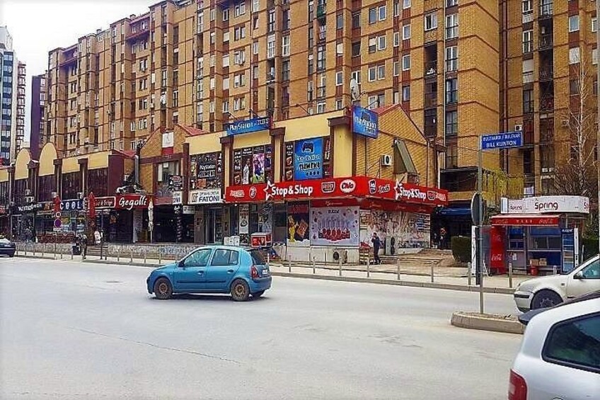 A multi-story building with various storefronts, including a 'Stop & Shop' and a 'Spring' store. 4