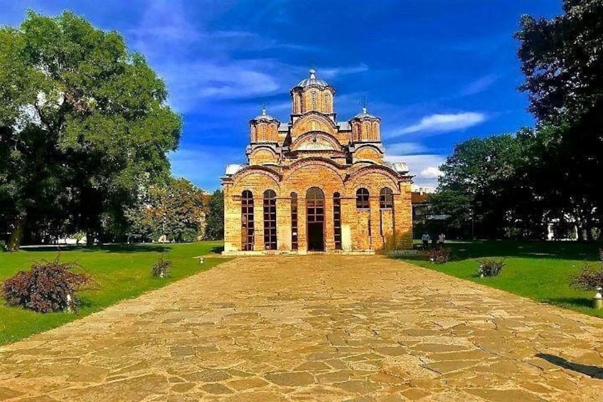 A large brick building with multiple domes, surrounded by a well-maintained lawn and trees. 5
