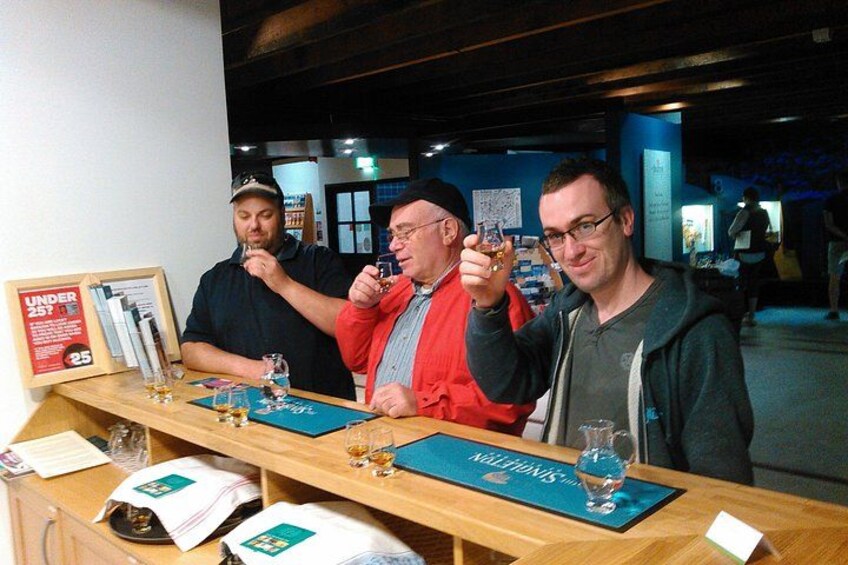Three people tasting different beverages at a tasting event. 3