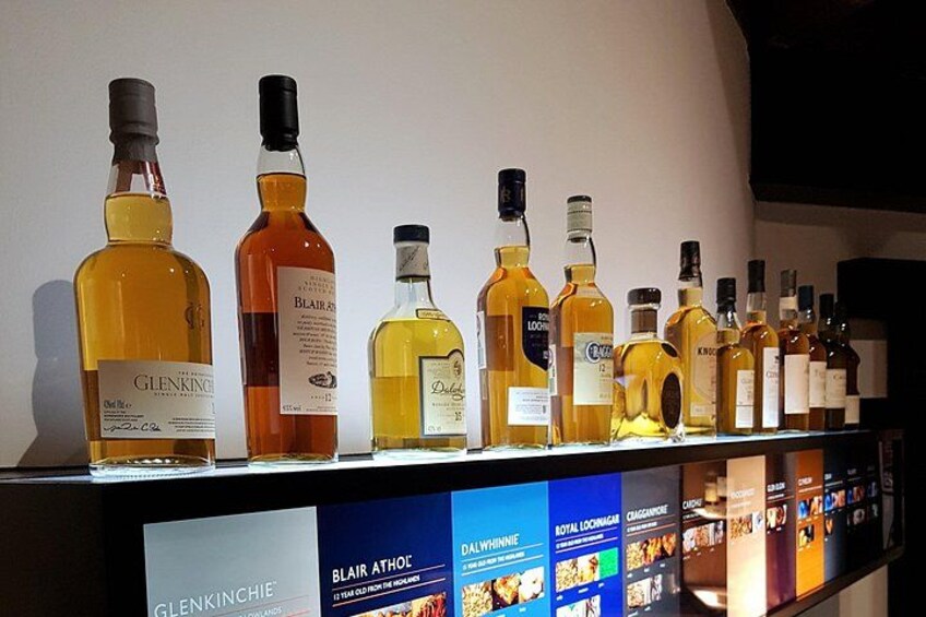 A shelf with various bottles of liquor, including Glenkinchie and Royal Loch Lomond. 2