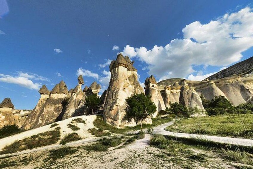 A landscape with distinctive rock formations, a pathway, and a clear sky. 2
