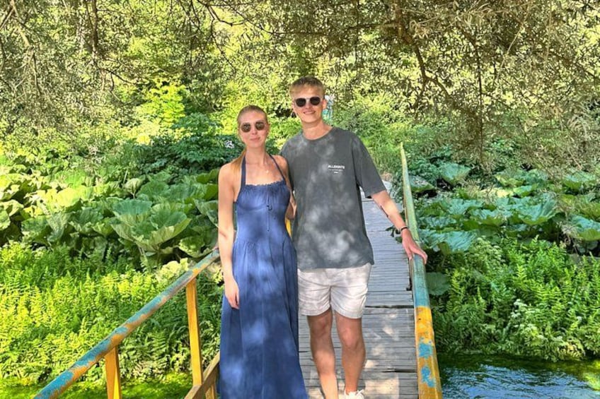 Un pont en bois enjambant une étendue d’eau, le tout entouré d’une végétation luxuriante. 2