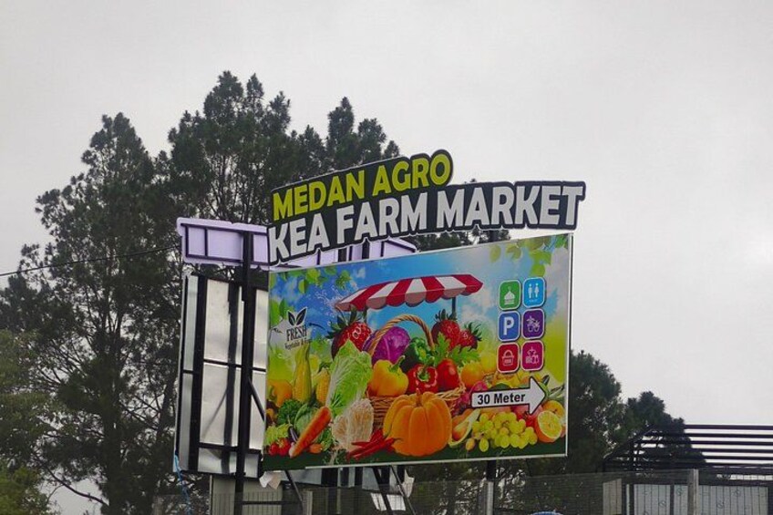 Une enseigne pour le marché agricole de Medan Agro KEA, avec un étalage coloré de fruits et de légumes. 4