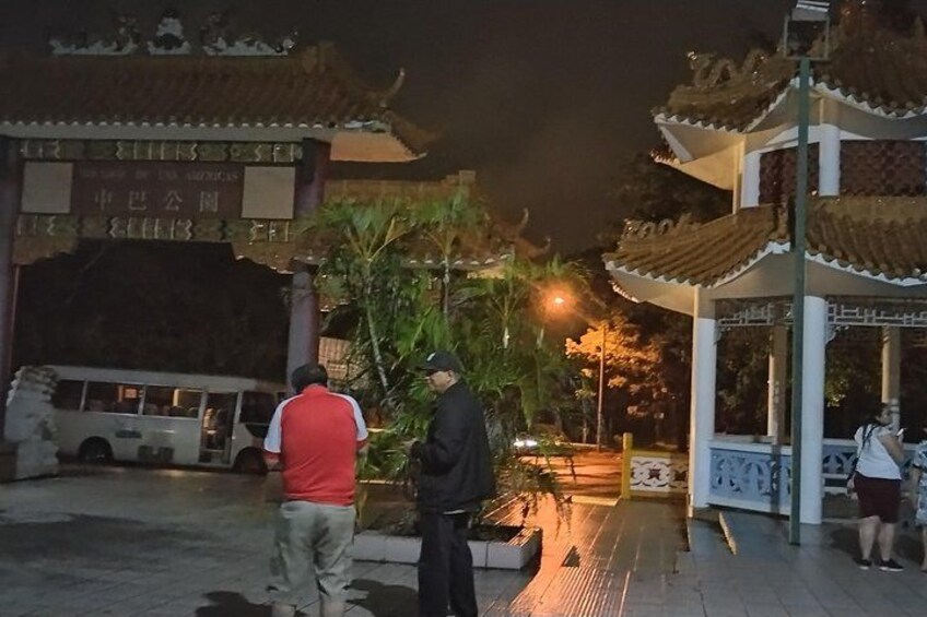 Une porte d’entrée de style chinois traditionnel, un véhicule blanc et une personne portant un gilet rouge. 3