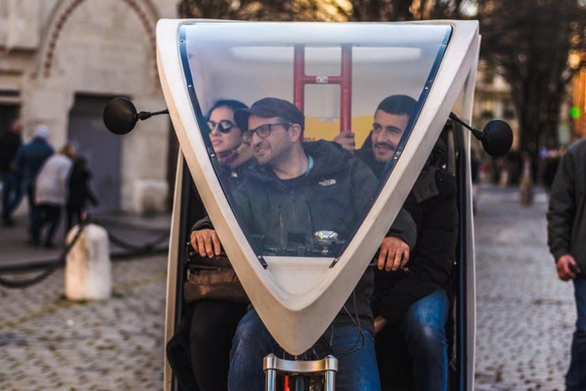 A unique, triangular-shaped vehicle with passengers inside. 1