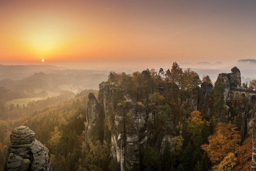 A mountainous landscape with rock formations and a sunset. 3