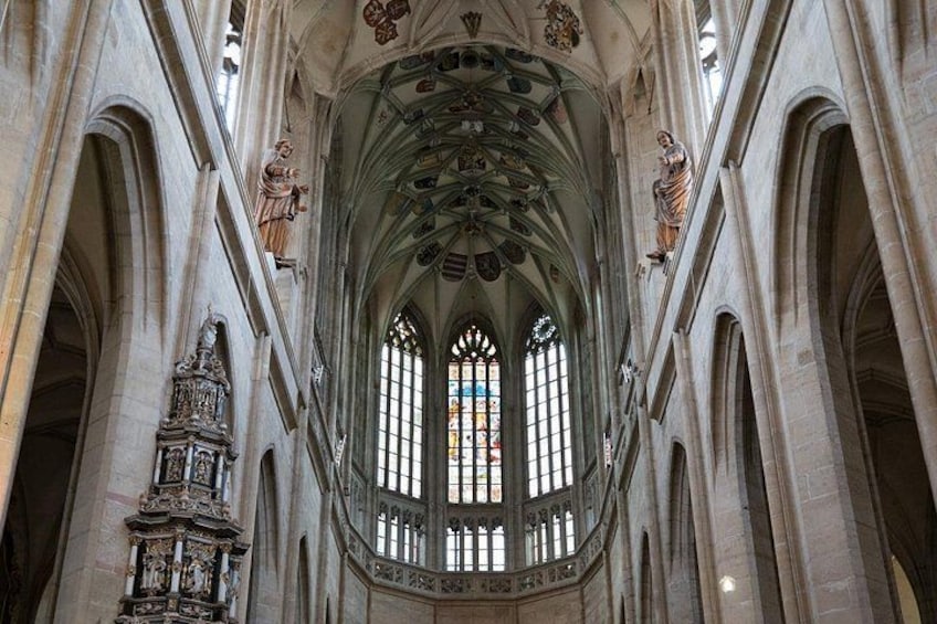 L’intérieur d’une cathédrale, avec ses fenêtres en arc, ses statues et un plafond richement décoré. 4