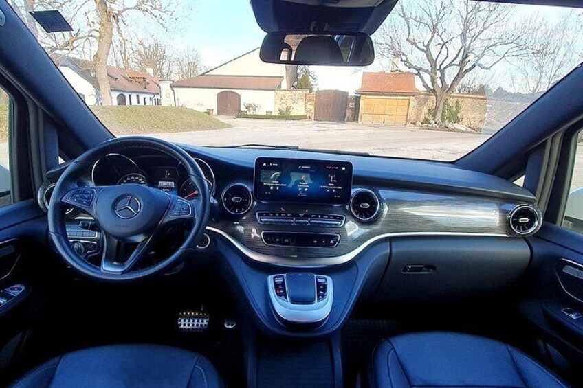 A car's interior with a steering wheel, dashboard, and center console. 3