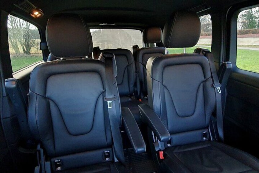 The interior of a car with three black leather seats and a central console. 2