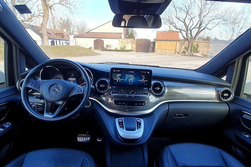 L'intérieur d'une voiture, avec un volant, un tableau de bord et une console centrale. 2