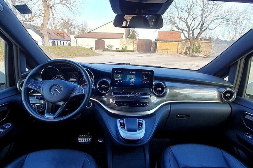 A car's interior with a steering wheel, dashboard, and center console. 2