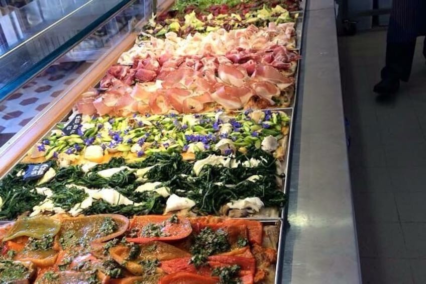 A deli counter with various meats and vegetables. 1