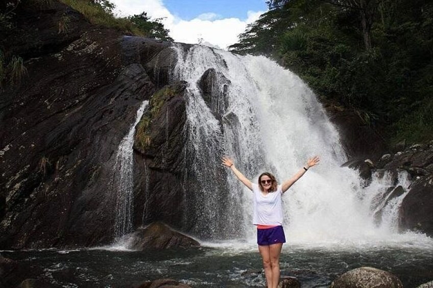 Une cascade avec une personne debout devant. 1