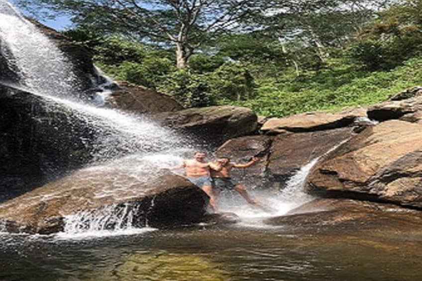 Una cascada, rocas y una persona en un entorno natural. 2