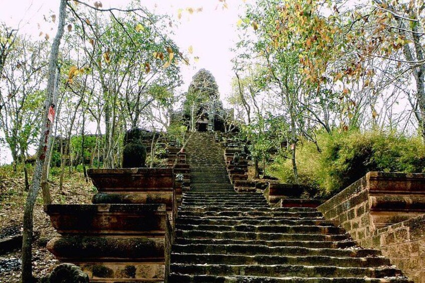 Una escalera de piedra que conduce a la entrada de un templo, rodeado de árboles. 4