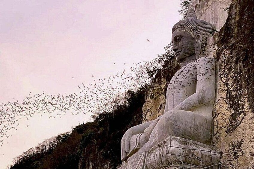 Una gran estatua de Buda sentado sobre un acantilado. 2