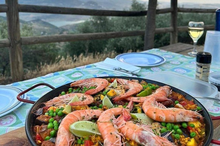 A seafood paella on a table with a scenic view. 3