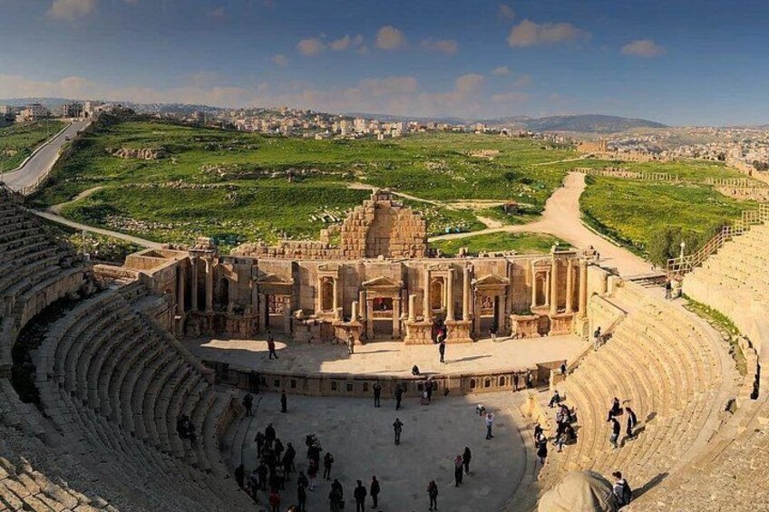 Un anfiteatro antiguo con ruinas, un escenario central y un área para el público. 4