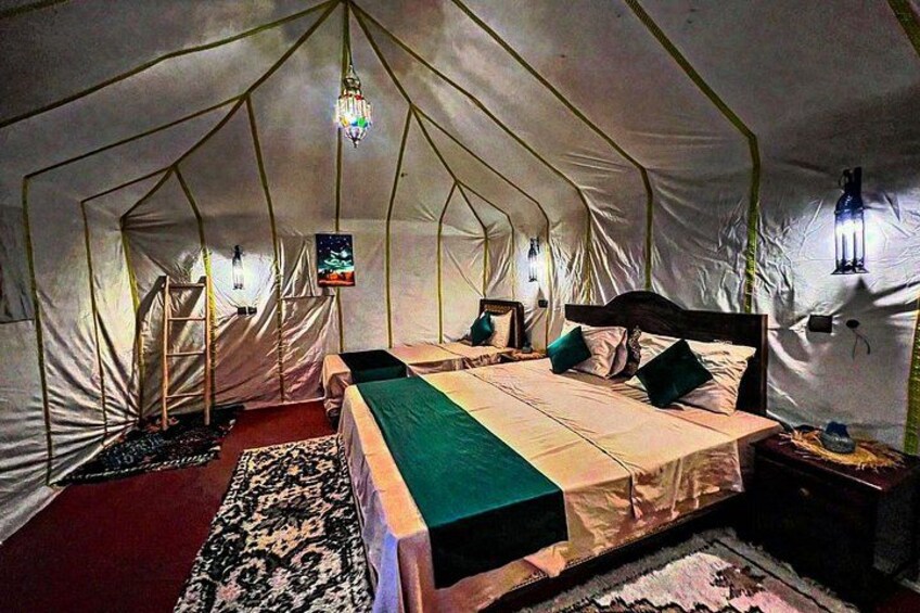 Una carpa con una cama, almohadas, una luz colgante y una escalera. 2