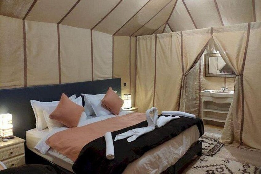 Une pièce aménagée avec une tente, un lit, des rideaux et un miroir. 4