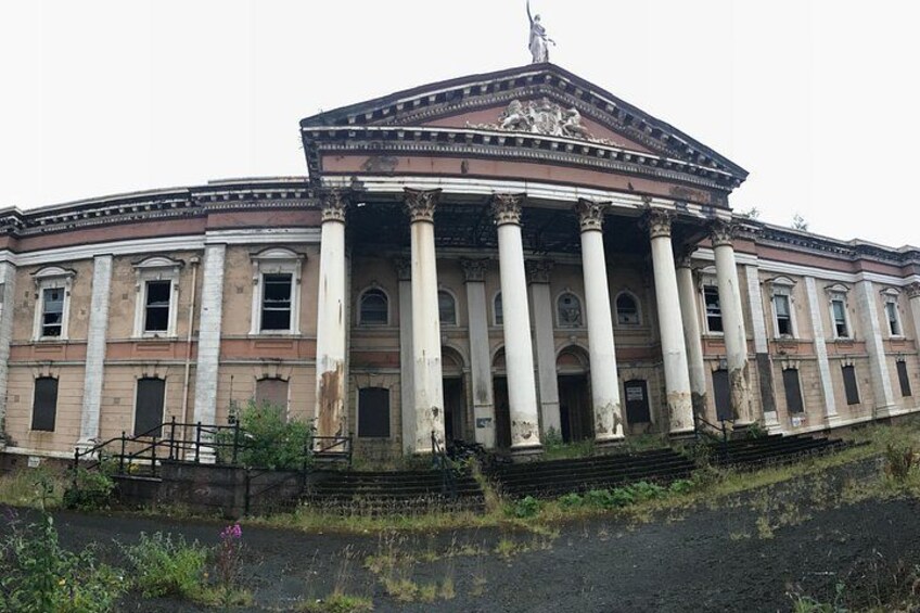 A large, historic building with classical architecture, featuring columns and a central pediment. 3