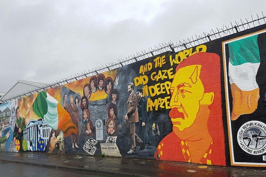 A mural on a wall with a large portrait of a man and text. 4