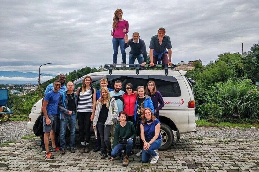 A group of people posing in front of a white van with the text 'DOORAHOLIK' on its side. 4