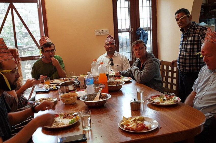 Un grupo de personas sentadas alrededor de una mesa de madera, comiendo y bebiendo. 5