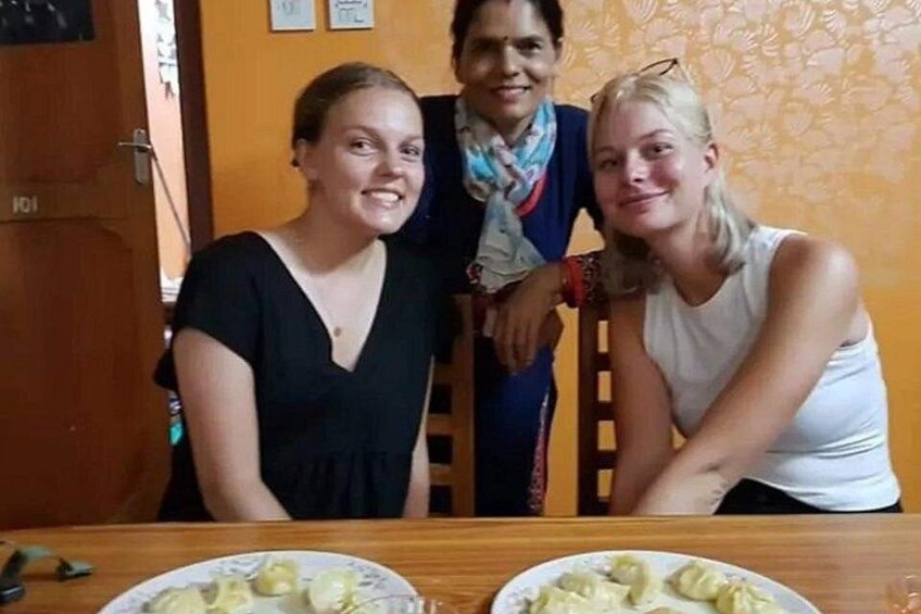 Tres personas de pie junto a una mesa con platos de comida. 4