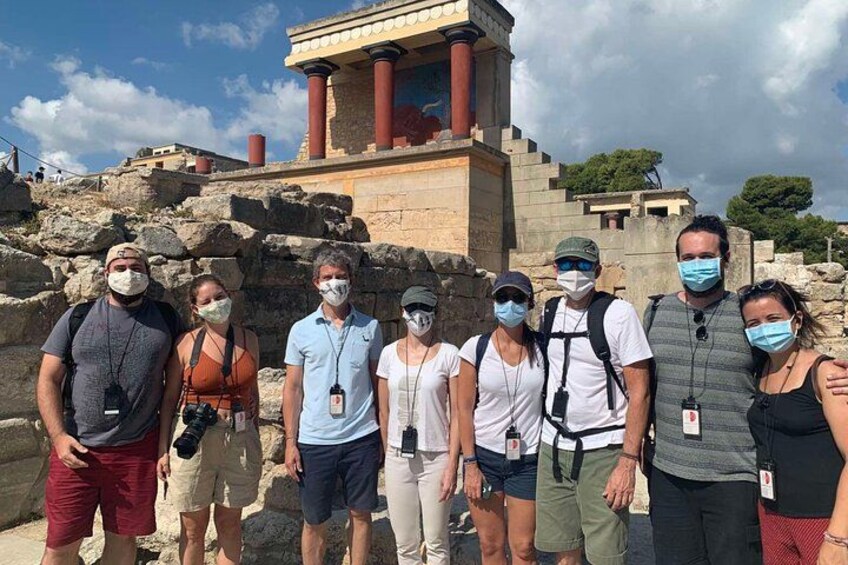 A group of people standing in front of an ancient ruin with columns and a temple-like structure. 4