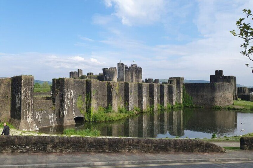 Een historisch kasteel met brede stenen muren en een gracht. 5