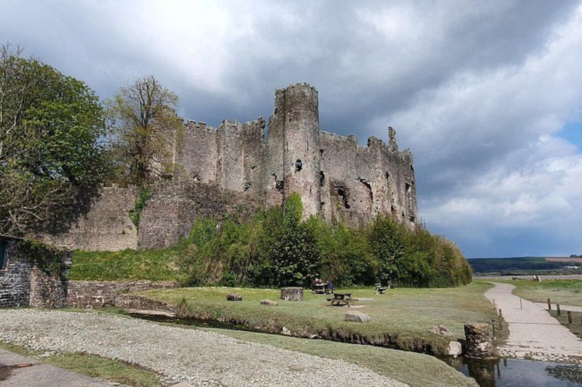 Un château historique en ruine, avec un parterre verdoyant et un sentier menant au château. 3