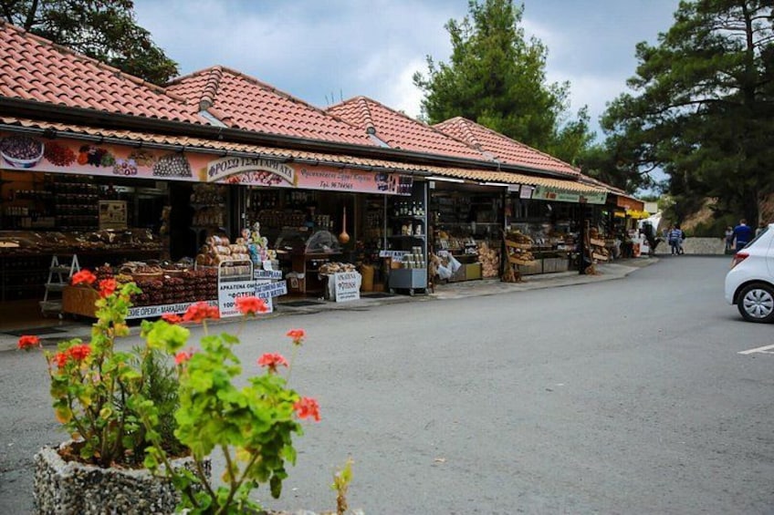 A street market with red-tiled roofs and various stalls selling goods. 3